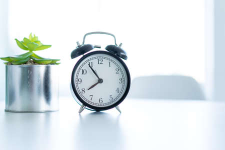 Retro alarm clock standing white table clear home background Morning Time conceptの写真素材