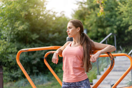 Confidence athletic woman standing sport ground in summer park looking away Caucasian sportive...