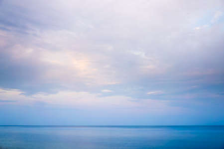 Beautiful dramtic cloudy sky sunset background under sea water With yellow orange colorsの写真素材