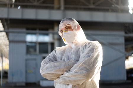 COVID-19 coronavirus doctor standing hospital parking dressed white protective overalls hazmat suit....