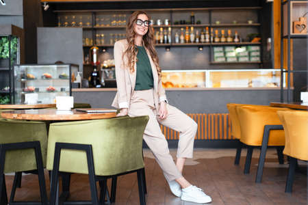 Business Woman Restaurant Owner Dressed Elegant Pantsuit Standing In Restaurant With Bar Counter Background Caucasian Female Glasses Business Person Indoor hands in pockets full lengthfull lengthの写真素材