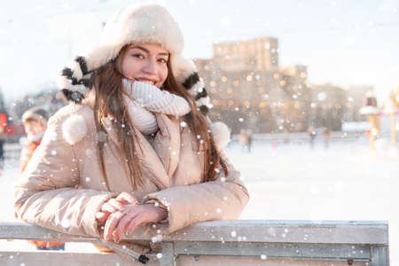 Beautiful lovely young woman long hair warm winter jackets funny fluffy hat stands outdoor on city street. Christmas mood lifestyle Happy holiday woman walk snowy day Winter leisureの写真素材