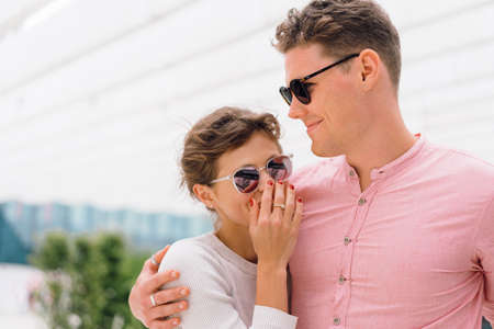 Smiling beautiful woman and her handsome boyfriend. Happy cheerful couple in sunglasses walking...