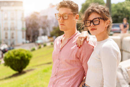 Young beautiful hipster couple in love walking on old city street, summer Europe vacation, travel, fun, happy, smiling, glasses, trendy outfit, romance, date, embracingの写真素材
