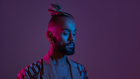 Neon light studio close-up portrait handsome black gay man looking camera. Seductive sexy man wear make up, transgender person in ultraviolet light. nightclub and nightlife conceptの写真素材