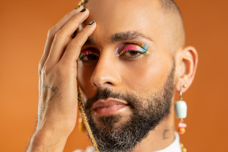 Trendy black latin gay man in white clothes look camera isolated on pink background studio portrait...