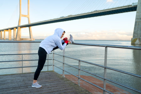 Athlete age woman stretching legs before kickboxing exercises. Caucasian athletic female does lunges...