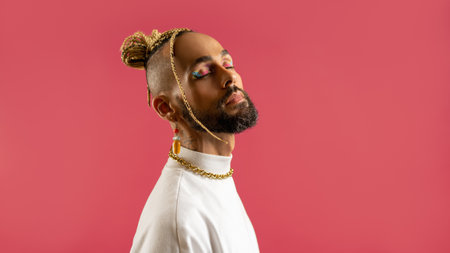 Trendy black latin gay man in white clothes with closed eyes isolated on pink background studio...