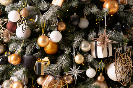 Christmas present gift box stacked close up. Holiday sale concept. Many gift box black, white, orange color with gold ribbon and light garlandの写真素材