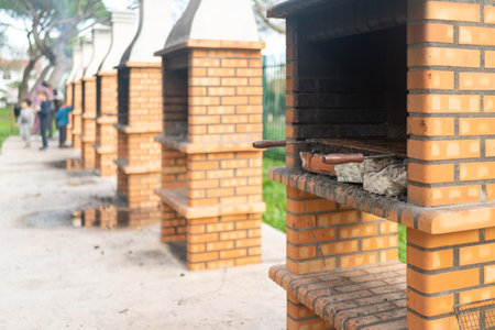 Barbecue fireplace with stack of chopped firewood in park for people for recreation. Open gazebo with barbecue area for relaxation and partiesの写真素材
