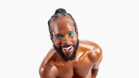 Smiling african-american bearded gay man with bright makeup isolated on white background. Exudes sense of pride and individuality. Diversity power of personality.の写真素材
