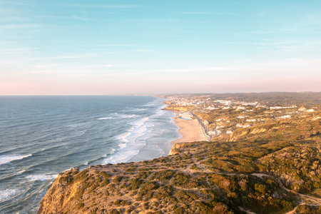 Sunset on the beach Praia Grande, Portugal. Beautiful sunset on the Portuguese beach Praia Grande, in Portugal. Beach of Praia Grande. View of Atlantic beach and big waves. Colares, Sintra, Portugal.の写真素材