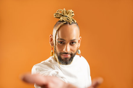 African-american gay with bright make up reaching empty open palm hand toward to camera. Mock up advertisement concept. Homosexual man outstretching empty hand towards camera. LGBT helpingの写真素材