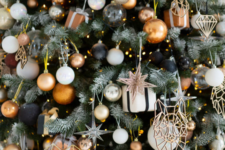 Christmas present gift box stacked close up. Holiday sale concept. Many gift box black, white, orange color with gold ribbon and light garlandの写真素材