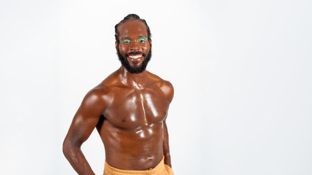 Positive African-American bearded gay man with bright makeup isolated on white background. Exudes sense of pride and individuality. Diversity power of personality.の写真素材