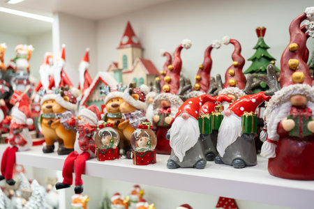Variety of artistic Christmas figurines are beautifully displayed on shelves in store, featuring festive characters like Santa, snowmen and reindeer, creating warm and cheerful holiday atmosphereの写真素材