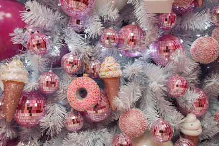 Closeup of shiny pink baubles and ice cream cones hanging on Christmas tree at home. Full frame shot of various festive decorations during Xmas eveの写真素材