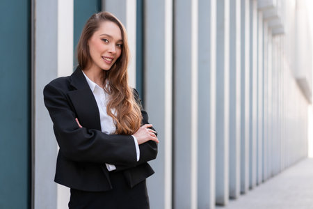 Portrait of smiling woman in business suit standing arms crossed. Young businesswoman with long hair...