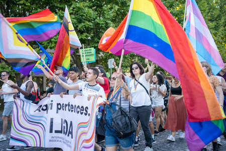 Lisbon, Portugal 17 June 2023 Participants proudly wave rainbow flags and banners during the LGBT gay parade, celebrating love and equality in the vibrant city center on a sunny day.のeditorial素材