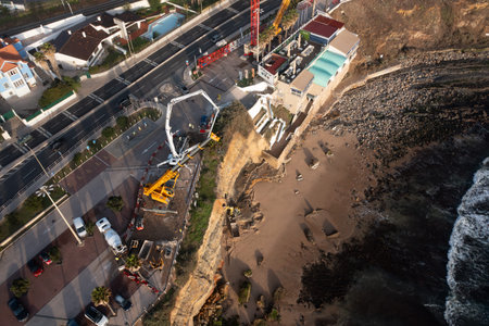 Aerial drone view of shoreline stabilization work with construction vehicles highlighting coastal development and infrastructure projectsの写真素材