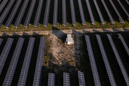 High angle view of rows of solar panels in countryside fields on sunny day, harnessing clean energy...