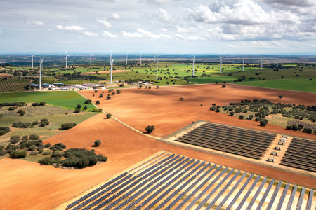 Aerial drone shot of solar and wind farms in vast field, highlighting the combination of solar and...