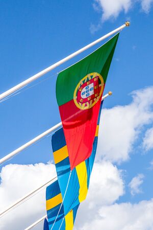 Portugese and Swedish Flags With Blue Sky in Backgroundの写真素材