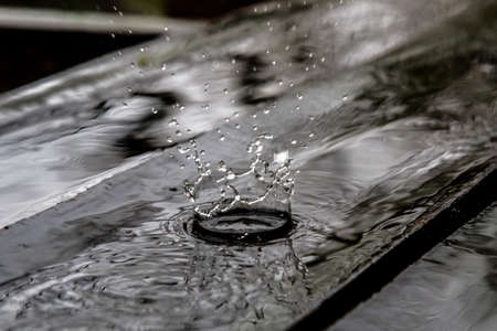 Rain drop splash in wooden floor bouncing and shaping water crownの写真素材