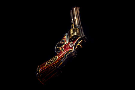 LONDON,ENGLAND,DECEMBER 10th,2018: pistol revolver isolated on black background. Jeweled revolver, customized .357 Magnum with red gold, red enamel and diamond decoration. Part of the Royal Armouriesのeditorial素材