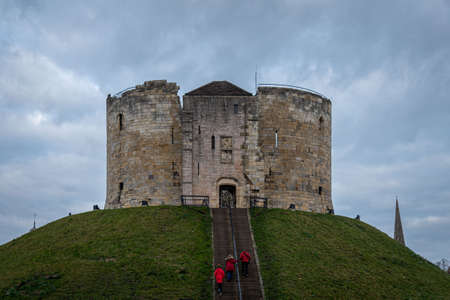 YORK, ENGLAND, DECEMBER 12, 2018: red dressed family entering to the Clifford's Tower castle in the historic city of Yorkのeditorial素材