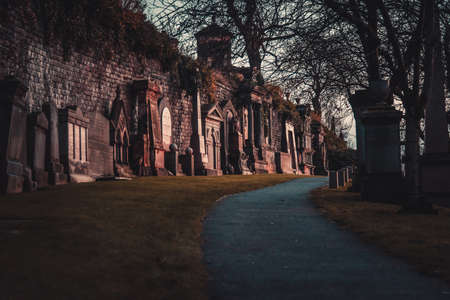 GLASGOW, SCOTLAND, DECEMBER 16, 2018: path to enter to the Glasgow Necropolis, surrounded quietly by lots of tombstones aside, shaping the wayのeditorial素材