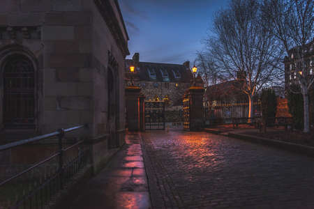 GLASGOW, SCOTLAND, DECEMBER 16, 2018: Beautiful cobbled street surrounded by old European style buildings. Illuminated only with weak light from street lampsのeditorial素材