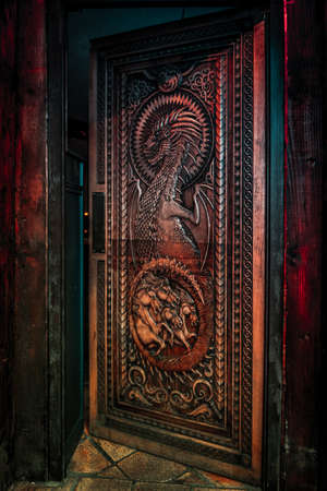 BALLINTOY HARBOUR, NORTHERN IRELAND, DECEMBER 20, 2018: Magnificent carved door with dragons and Dothraki horses, made with wood from the Dark Hedges. Location feautered in HBO Game of Thronesのeditorial素材