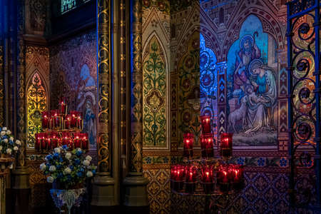 DUBLIN, IRELAND, DECEMBER 21, 2018: Magnificent color decorated walls from interior of John's Lane Church, shaping biblical drawings while illuminated softly by candlesのeditorial素材