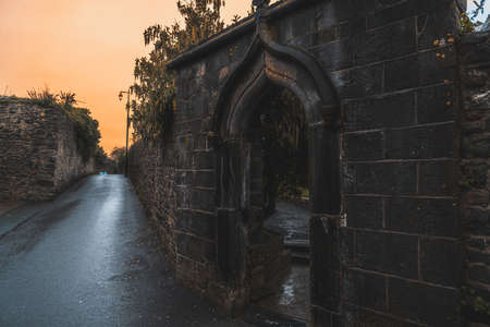 KILKENNY, IRELAND, DECEMBER 23, 2018: Spooky old stone and very wet entrance gate of a graveyard with mold and lichen growing. Concept of desolation and damageのeditorial素材