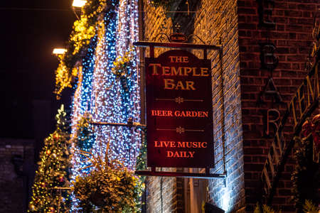 DUBLIN, IRELAND, DECEMBER 24, 2018: Temple Bar historic district, known as cultural quarter with lively nightlife. Nightscene of the bar, full of neon lights and its typically irish pub look.のeditorial素材