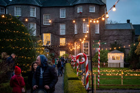 KILKENNY, IRELAND, DECEMBER 23, 2018: People in christmas market, waking along a decorated and illuminated path with festive new year lights and giant christmas candies.のeditorial素材
