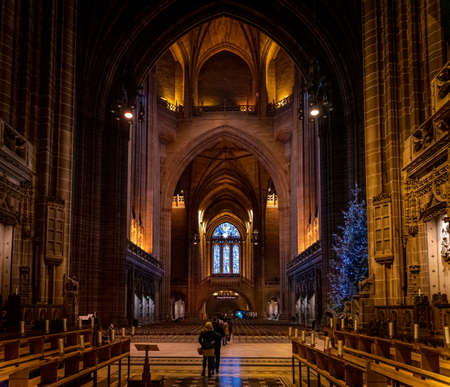 LIVERPOOL, ENGLAND, DECEMBER 27, 2018: People walking along the entrance hall of the Church of England Anglican Cathedral of the Diocese of Liverpool with a christmas tree aside during holidays.のeditorial素材