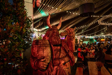 LONDON, ENGLAND, DECEMBER 28, 2018: People enjoying a pleasant time in a Christmas market, surrounded by food and drink stands, decorated with lights, wreaths and other christmas themesのeditorial素材