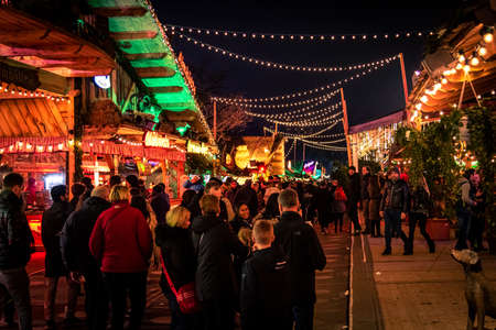 LONDON, ENGLAND, DECEMBER 28, 2018: People enjoying a pleasant time in a Christmas market, surrounded by food and drink stands, decorated with lights, wreaths and other christmas themesのeditorial素材