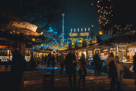 LONDON, ENGLAND, DECEMBER 28, 2018: People enjoying a pleasant time in a Christmas market, surrounded by food and drink stands, decorated with lights, wreaths and other christmas themesのeditorial素材
