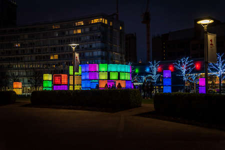 LIVERPOOL, ENGLAND, DECEMBER 27, 2018: Silhouettes of people having fun at night while posing in front of cubes illuminated with different light colours during christmas timeのeditorial素材