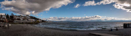 BARILOCHE, ARGENTINA, JUNE 18, 2019: Panoramic view of the lake Nahuel Huapi and the cityscape of Bariloche in Argentina, with snowed mountains in the background, seen from stony coastのeditorial素材
