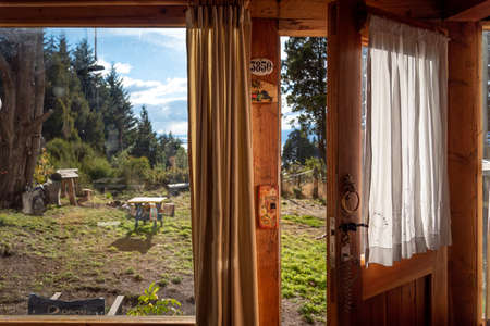 BARILOCHE, ARGENTINA, JUNE 18, 2019: An open door seen from the interior of a wooden cozy and...