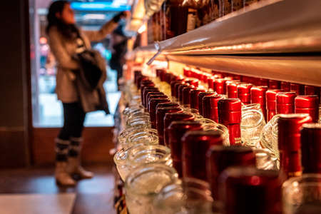 Perspective view of a bokeh of a woman shopping for wine or other alcohol in a liquor storeの写真素材