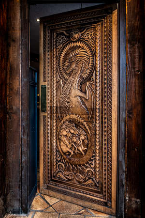 BALLINTOY HARBOUR, NORTHERN IRELAND, DECEMBER 20, 2018: Magnificent carved door with dragons and Dothraki horses, made with wood from the Dark Hedges. Location feautered in HBO Game of Thronesのeditorial素材