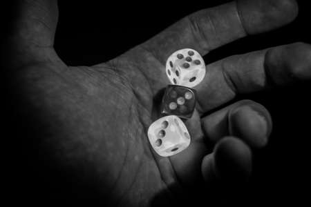 Hand holding dices that glow in the dark. Concept of risk, bet and adictionの写真素材