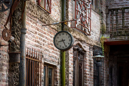 GONZALEZ CATAN, ARGENTINA, SEPTEMBER 28, 2019: Very old watch hanging from a brick wall of abandoned building in the amazing medieval town of Campanopolis.のeditorial素材