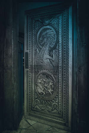 BALLINTOY HARBOUR, NORTHERN IRELAND, DECEMBER 20, 2018: Magnificent carved door with dragons and Dothraki horses, made with wood from the Dark Hedges. Location feautered in HBO Game of Thronesのeditorial素材