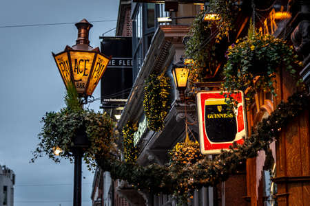 DUBLIN, IRELAND, DECEMBER 24, 2018: Close up of the exterior of the Palace Bar, decorated for Christmas on Fleet Street, with a street lamp with its name written and a Guinness signのeditorial素材